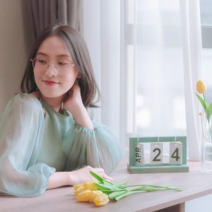 实习编辑小陆，短发圆脸，在窗边翻看纸质书，阳光洒在页面上，神态专注